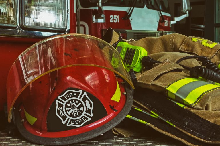 Stacked firefighter gear in front of a firetruck.